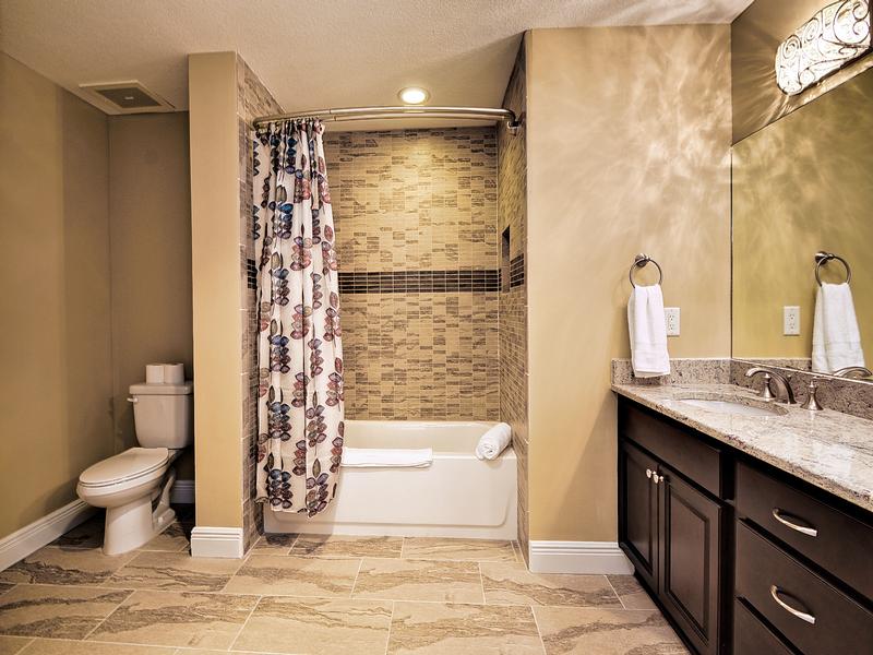 Guest bathroom has shower  tub combo.
